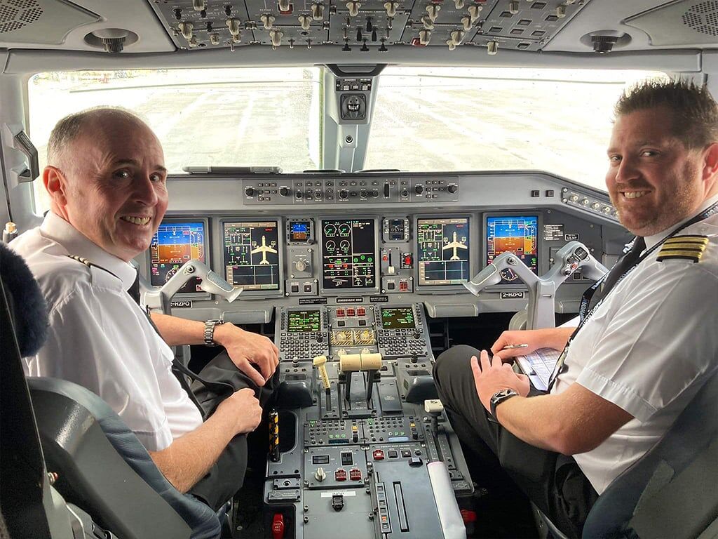 Two pilots in a cockpit on a runway