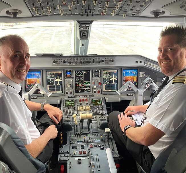 Two pilots in a cockpit on a runway