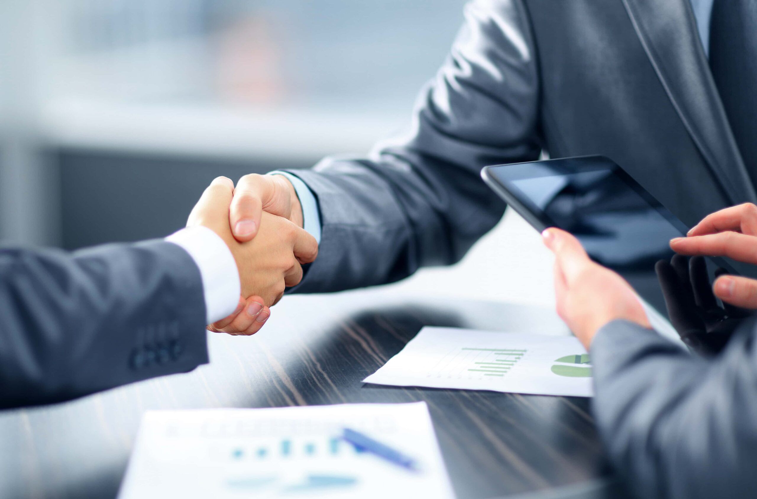 Businessmen seal deal with handshake at a table