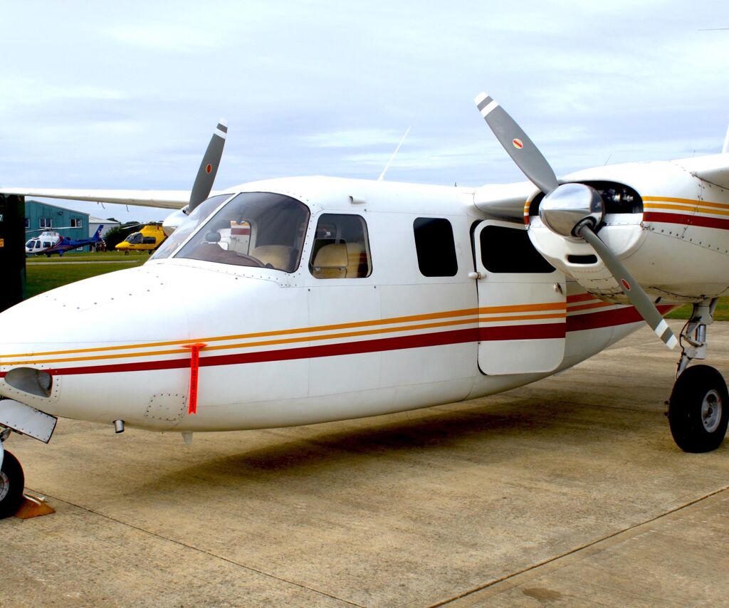 Side view of Aero Commander 500 N711NE showing fuselage and propellers